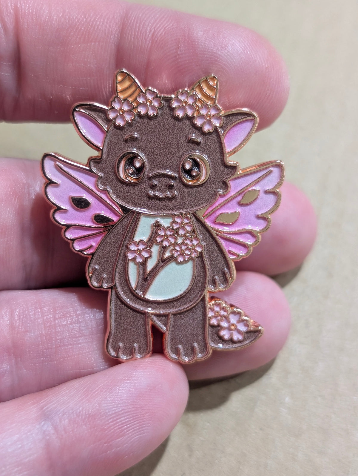 Cherry Blossom Dragon sneak peek enamel pin held in hand