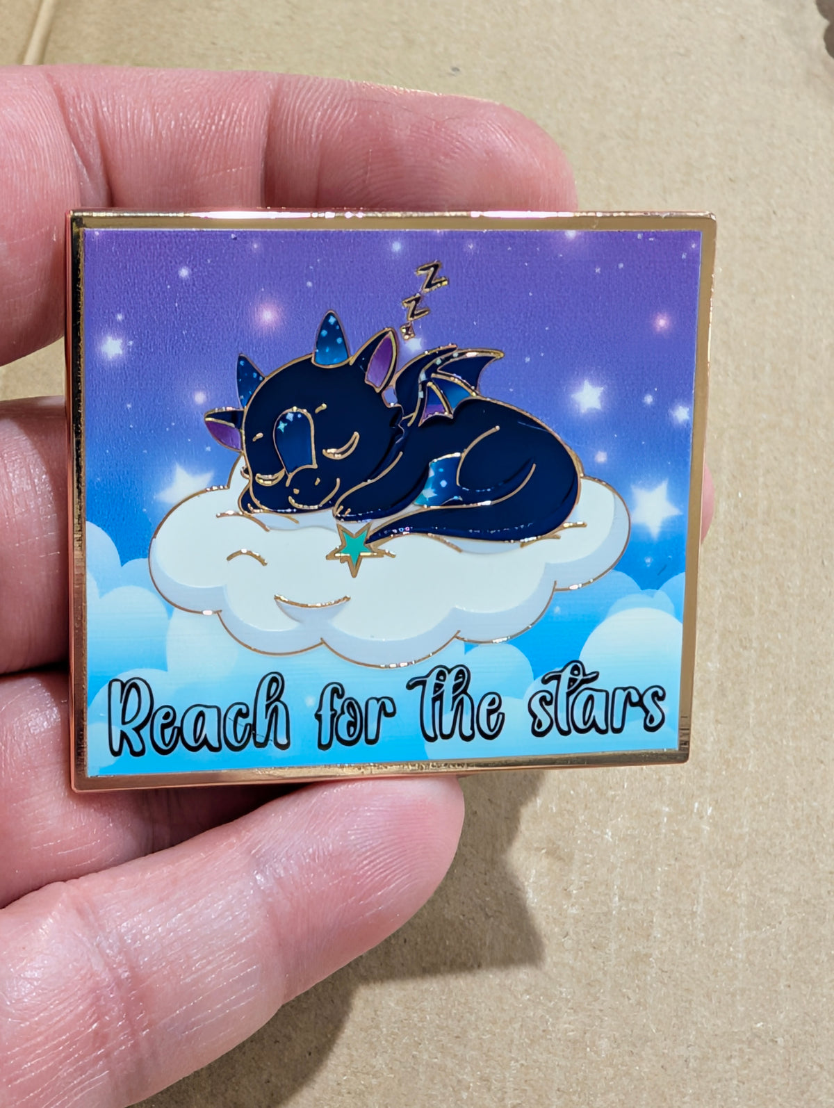 Norrhys Reach for the Stars hard enamel pin: a sleeping galaxy dragon on a smiling cloud